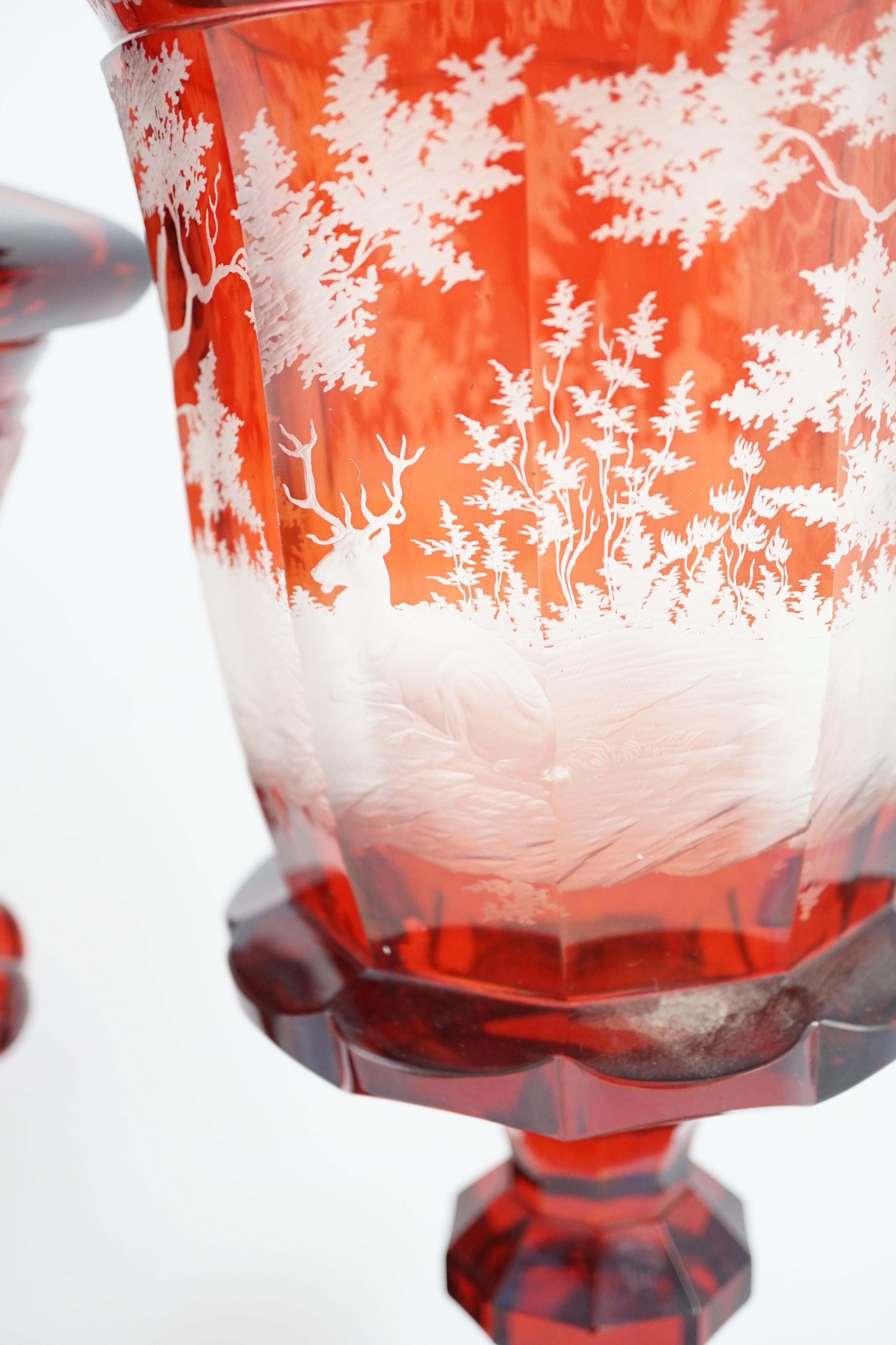 Three large Bohemian ruby stained glass goblets and covers, late 19th century, 38.5cm to 50.5cm high, rim chips